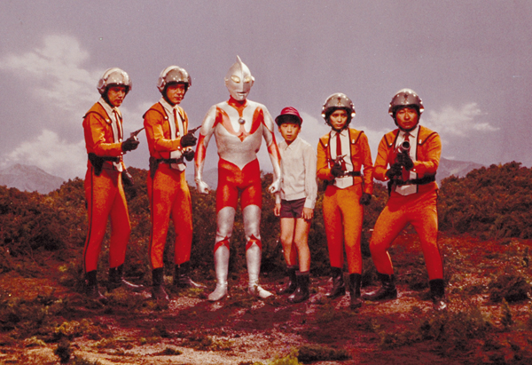 Ultraman entouré des membres de l’AIS et du jeune Hoshino Isamu qui avait obtenu l’autorisation de rejoindre l’équipe. CR :Tsuburaya Pro