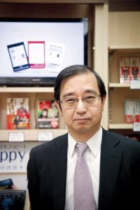 Tokyo, February 15 2012 - Portrait of Ushiguchi Junji, general manager of eCommerce division of Kinokuniya book stores, in front of the ebooks corner of the main Tokyo store in Shinjuku.